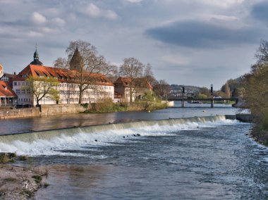 Arka planda eski binalarla akan nehrin manzarası.
