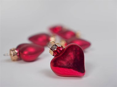 Beyaz bir taşra üzerinde kalp şeklinde kırmızı bir Noel ağacı süslemesinin seçici bir odak noktası.