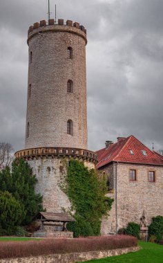 Bulutlu gökyüzünün altındaki bir kalenin dikey görüntüsü.