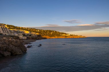 Facade on the sea of the buildings of the Crique de l'Anau at sunset