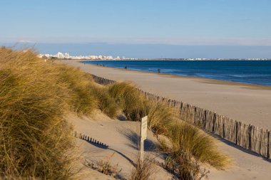View of the buildings of La Grande-Motte on the horizon from Petit Travers beach in Carnon
