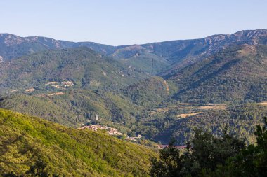 Sunny view of the medieval village of Olargues and the surrounding mountains of the Haut-Languedoc Regional Natural Park