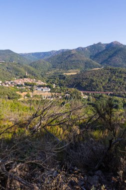 Sunny view of the medieval village of Olargues and the surrounding mountains of the Haut-Languedoc Regional Natural Park