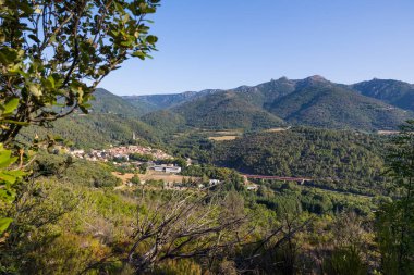 Sunny view of the medieval village of Olargues and the surrounding mountains of the Haut-Languedoc Regional Natural Park