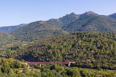 View of the Olargues railway bridge, incorrectly called the 'Eiffel Bridge', spans the Jaur in the Haut-Languedoc Regional Nature Park