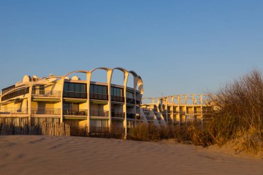 View of the buildings of the Couchant district from the dunes of the beach in La Grande-Motte at sunset