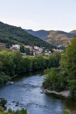 Gün batımında Haut-Languedoc Doğa Parkı 'ndaki Kürenin kıyısındaki Ceps köyüne bakın.