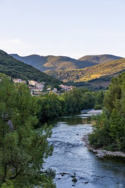 Gün batımında Haut-Languedoc Doğa Parkı 'ndaki Kürenin kıyısındaki Ceps köyüne bakın.