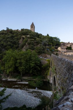 Saint-Laurent d 'Olargues Kilisesi' nin çan kulesi Pont du Diable 'dan gün batımında