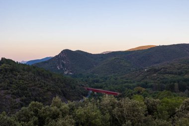 Gün batımında Haut-Languedoc Doğal Parkı 'nın dağlarının önündeki Olargues demiryolu köprüsü.