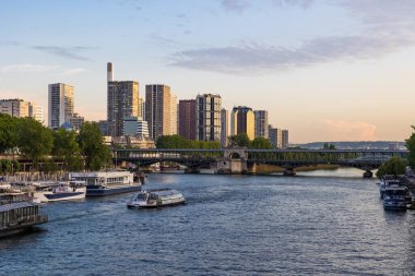 Sen nehrinde, Beaugrenelle binalarının önünde gün batımında Pont d 'Iena' dan gelen bir tekne.