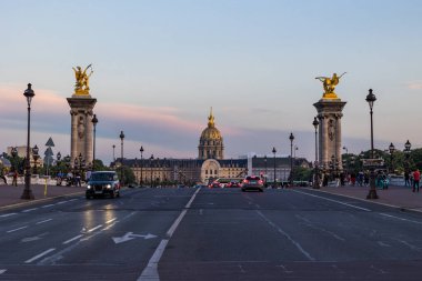 Günbatımında Paris 'teki Alexandre III köprüsünün kuzeyinden Invalides' in perdesine bakan manzara.