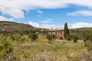 Cayroux Platosu 'nun eteklerindeki batının ortasında küçük kırmızı taştan bir ev.