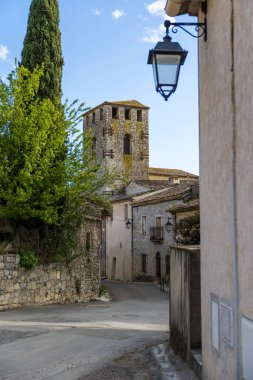 Notre-Dame-de-l 'Assomption kilisesinin çan kulesi. Matelles' in ortaçağ köyündeki bir ara sokaktan.