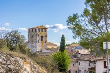 Notre-Dame-de-l 'Assomption kilisesinin çan kulesi. Matelles' in ortaçağ köyündeki bir ara sokaktan.