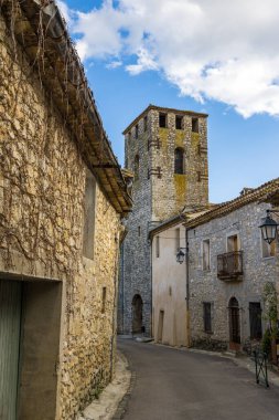 Notre-Dame-de-l 'Assomption kilisesinin çan kulesi. Matelles' in ortaçağ köyündeki bir ara sokaktan.