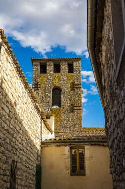 Notre-Dame-de-l 'Assomption kilisesinin çan kulesi. Matelles' in ortaçağ köyündeki bir ara sokaktan.