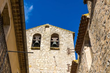 Notre-Dame-de-l 'Assomption kilisesinin çan kulesi. Matelles' in ortaçağ köyündeki bir ara sokaktan.
