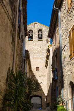 Notre-Dame-de-l 'Assomption kilisesinin çan kulesi. Matelles' in ortaçağ köyündeki bir ara sokaktan.