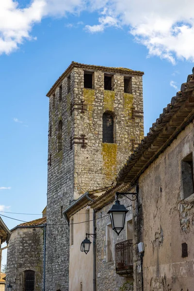 Notre-Dame-de-l 'Assomption kilisesinin çan kulesi. Matelles' in ortaçağ köyündeki bir ara sokaktan.