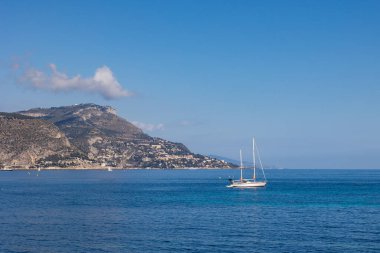 Akdeniz 'in berrak sularında Beaulieu-sur-Mer yakınlarında küçük bir yelkenli.