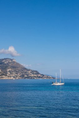 Akdeniz 'in berrak sularında Beaulieu-sur-Mer yakınlarında küçük bir yelkenli.