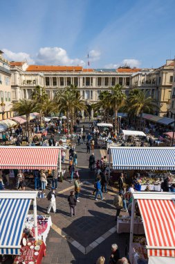 Sardunya krallarının eski sarayı Palais de la Bölgesi 'nin cephesi, Cours Saleya' dan, bit pazarında insanlarla dolup taşıyor.