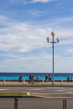Nice 'teki Gezinti Güvertesi' nde yürüyenler ve bisikletçiler. Deniz kenarında.
