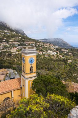 Eze 'deki Notre-Dame-de-l' Assomption kilisesinin çan kulesi. Arka planda Tete au Chien 'in zirvesi var.