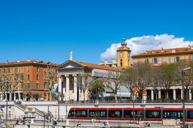 Port Lympia 'nın kıyısındaki Notre-Dame-du-Port de Nice Kilisesi' nin önünde tramvay var.