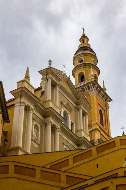 Aziz Mikail, Menton Başmelek Bazilikası. Kara bulutların altında. Merdivenlerden Eski Liman 'a iniyor.