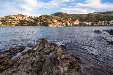 Fort Saint-Elme ve Moulin de la Cortina Collioure 'daki Port d' Avall plajının yukarısında gün batımında.