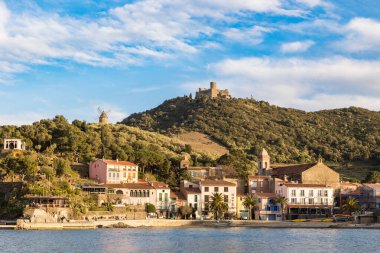 Fort Saint-Elme ve Moulin de la Cortina Collioure 'daki Port d' Avall plajının yukarısında gün batımında.