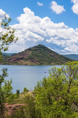 Yarımada 'yı ve Salagou Gölü kıyısındaki antik yanardağını geçiyor.