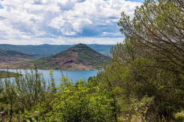 Yarımada 'yı ve Salagou Gölü kıyısındaki antik yanardağını geçiyor.