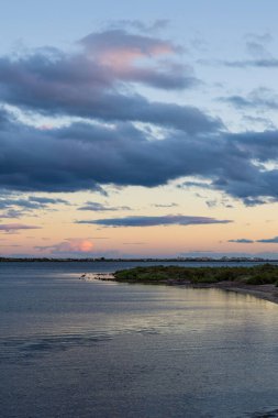 Gün batımında Etang d 'Ingril' in kenarında bir balıkçıl silueti.