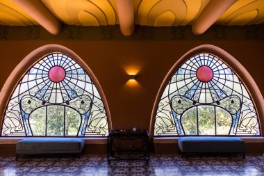 Şato Laurens 'ın birinci katındaki demiryolu raylarına bakan sanat eserlerine ait işlenmiş demiryolu süslemeleri olan büyük bir pencere.