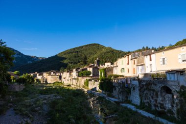 Rieutord nehri etrafındaki Sümne köyü, Cevennes 'in güneyinde, sabahın erken saatlerinde güneşin altında.