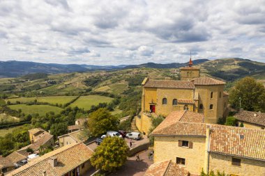 Oingt 'in ortaçağ köyü, Beaujolais bölgesinin tipik altın taşlarla inşa edilmiş. Kalenin tepesinden tepedeki tepe ve üzüm bağlarından oluşan bir manzaraya bakıyor.