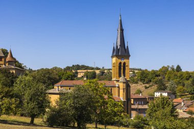 Golden stone bell tower of the Saint-Etienne Church in the village of Jarnioux, in Beaujolais clipart