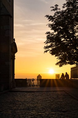 Lyon 'un Fourviere bölgesindeki Part-Dieu iş bölgesinin kuleleri üzerinde gün doğumunu hayal eden insanların siluetleri.