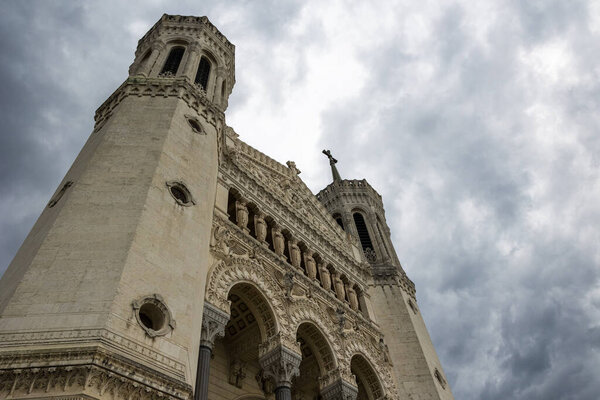 Facade of Fourvire Basilica in Lyon on a cloudy day