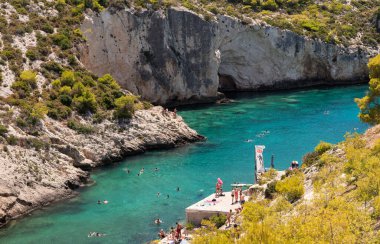 Zakynthos, Yunanistan 27 Temmuz 2023. Yunanistan 'ın Zakynthos adasındaki Limnionas plajında yerel halk ve turistler yazın keyfini çıkarıyorlar.
