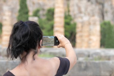 Yunanistan 'ın Delphi bölgesindeki Apollo tapınağında fotoğraf çeken bir kadın.