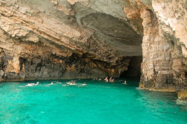 Zakynthos, Yunanistan 28 Temmuz 2023. Yunanistan 'ın Zakynthos adasındaki mavi mağaralarda yüzen insanlar. Ünlü turistik mekan.