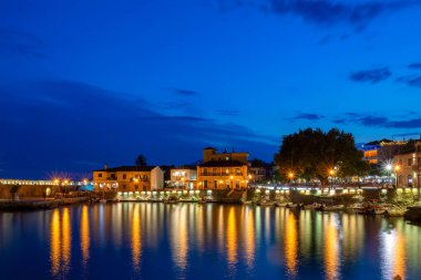 Nafpaktos limanı, mavi saat. Şehir ışıklarının suyu yansıttığı güzel bir turistik yer..