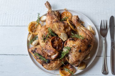 Tavuk budu, kekik ve sarımsaklı İtalyan limonlu tavuk. Beyaz ahşap arka planda izole edilmiş bir tabakta servis ediliyor.