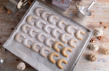 Gümüş renkli fırın tepsisinde taze pişmiş noel kurabiyeleri. Vanillekipferl. Düz yatıyordu