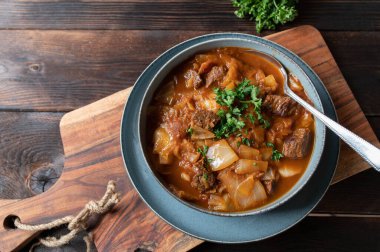 Tahta masada doğranmış biftekli Romen lahana çorbası. Yukarıdan gelen metin için boşluk ile yan görünüm