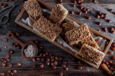 Nut cake with caramelized hazelnut topping on wooden background. Flat lay